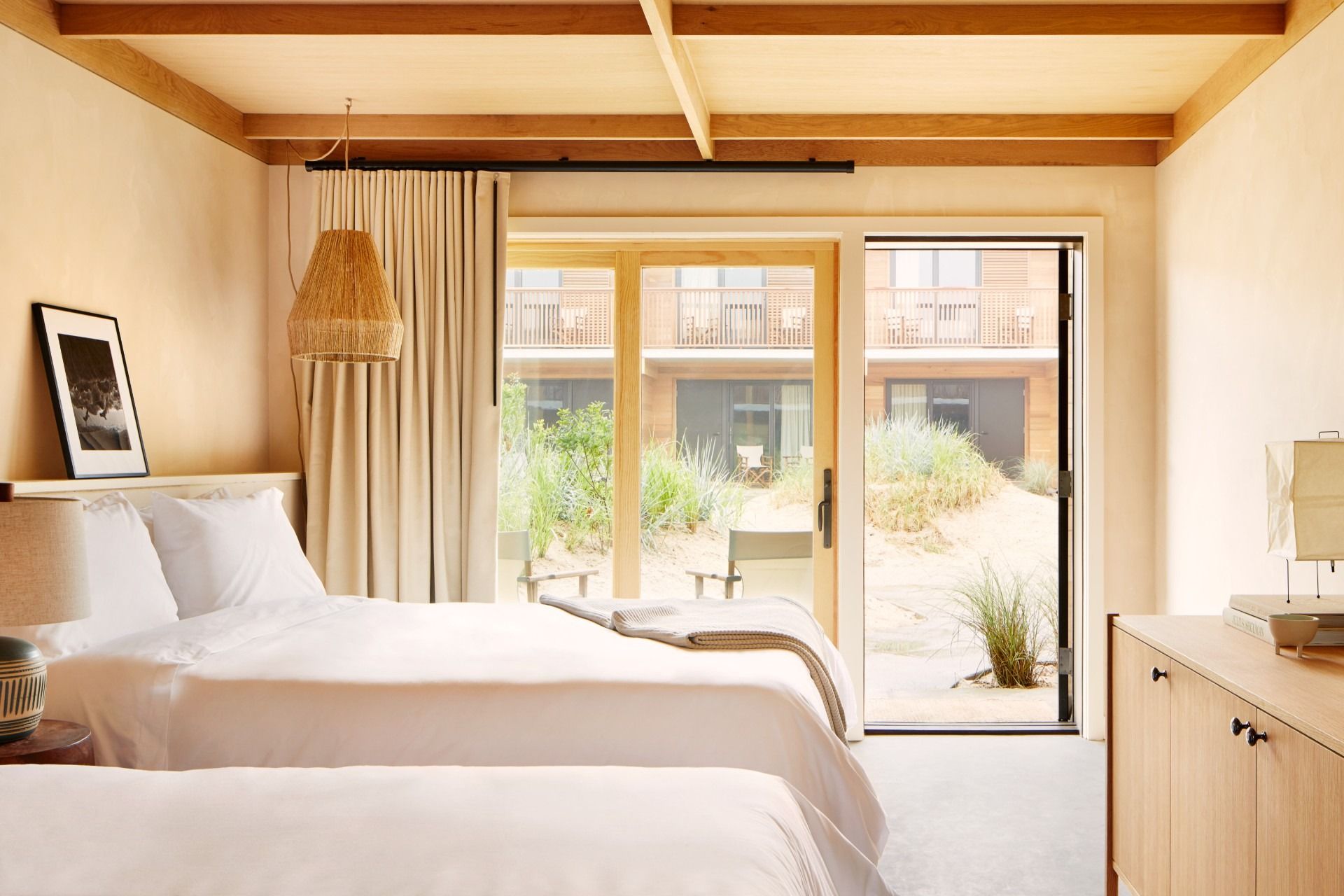 A king bed, a curtain, a glass door, a patio