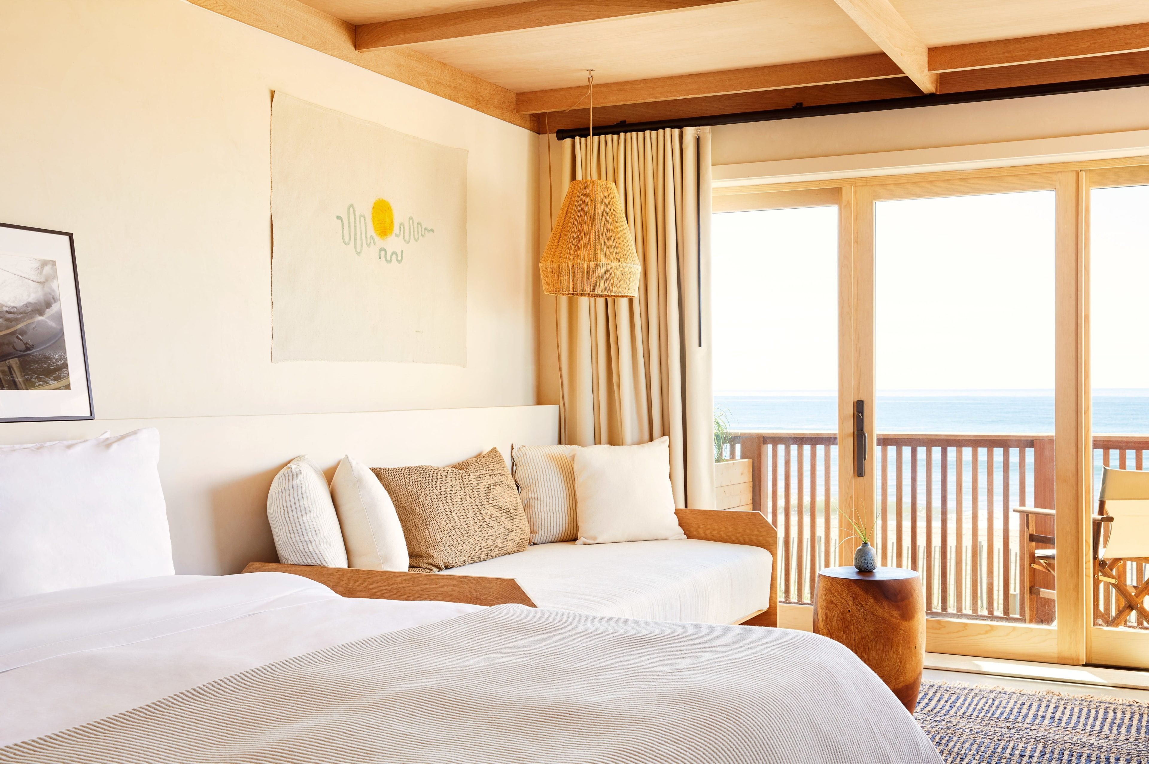 A king bed, a daybed and a balcony overlooking the ocean