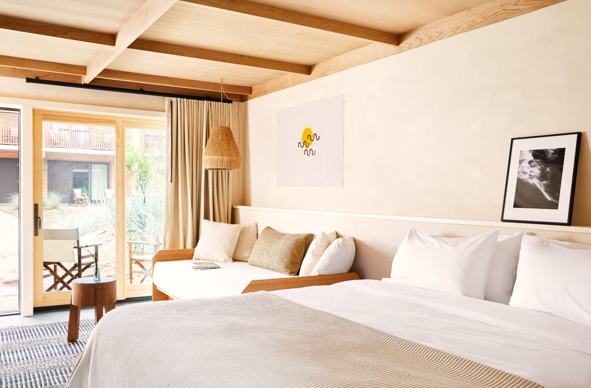 A king bed, a daybed, a curtain, a glass door, a patio