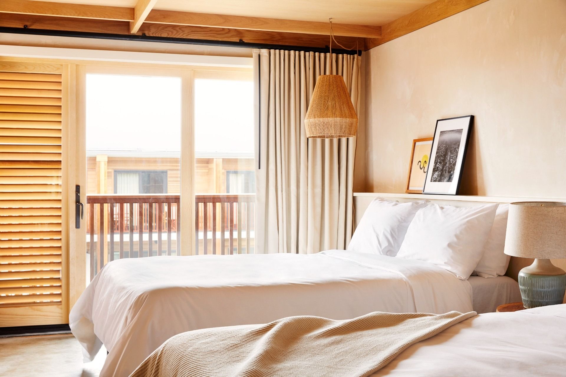 Two queen beds with a sliding glass door looking out.