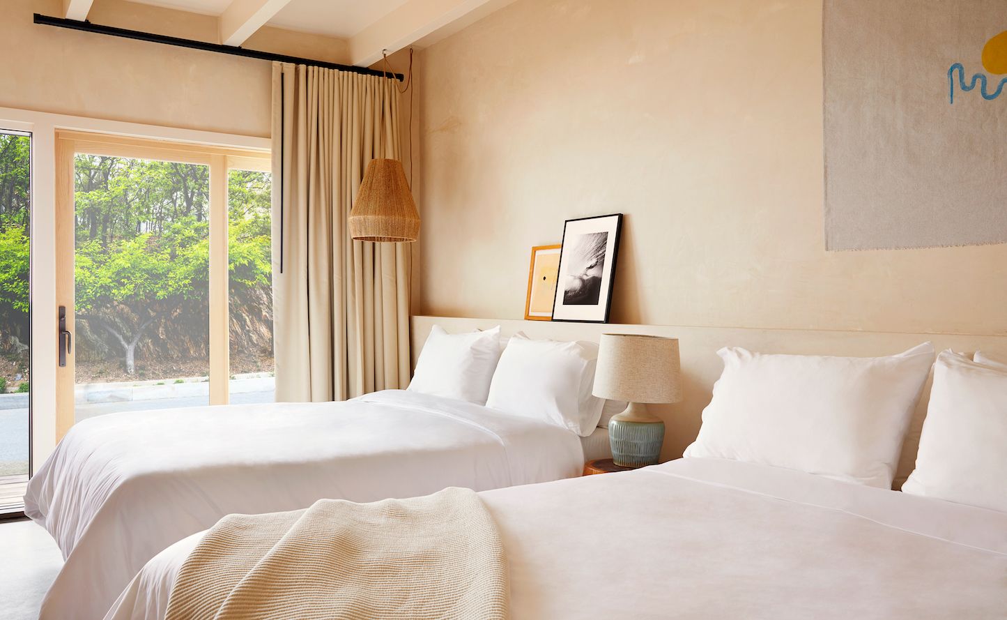 Two queen beds, a curtain, glass doors, a patio